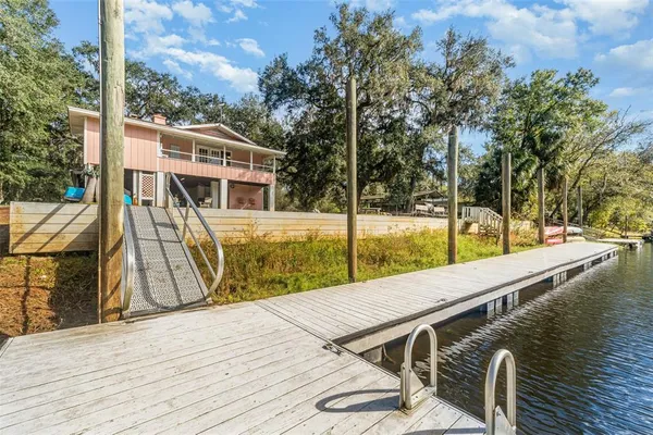 a view of a roof deck with wooden floor and fence next to a yard