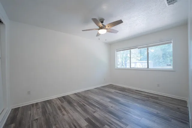 a view of a room with wooden floor and windows