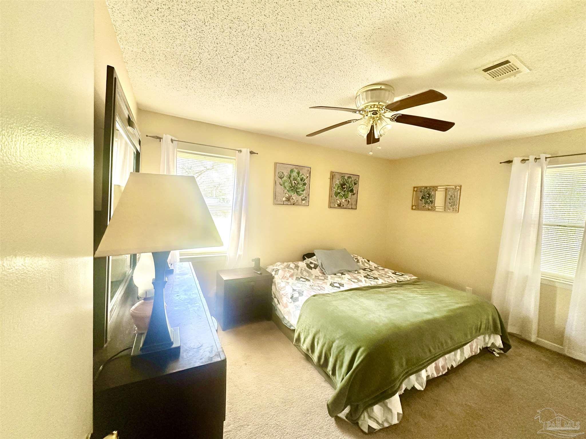 5057 Babb Lane Pace, FL 32571 - Photo 18 of 33 a bedroom with a bed and a lamp