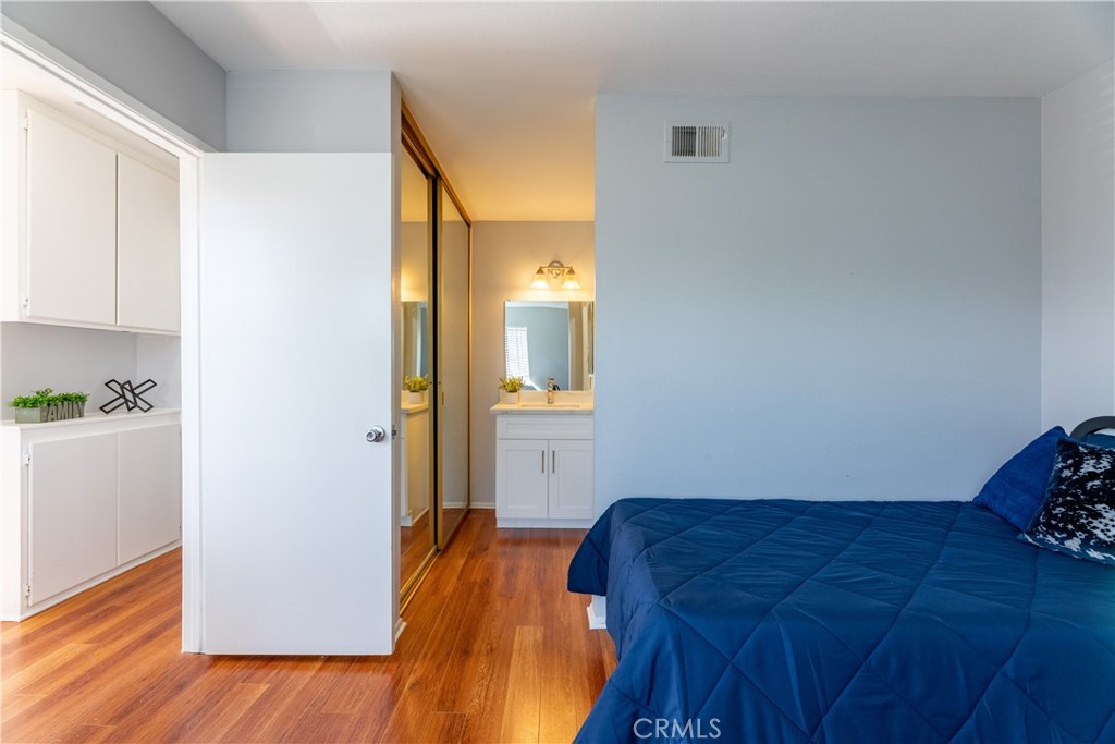 12635 Briarglen Loop, Unit H Stanton, CA 90680 - Photo 25 of 43 a bedroom with a bed and wooden floor