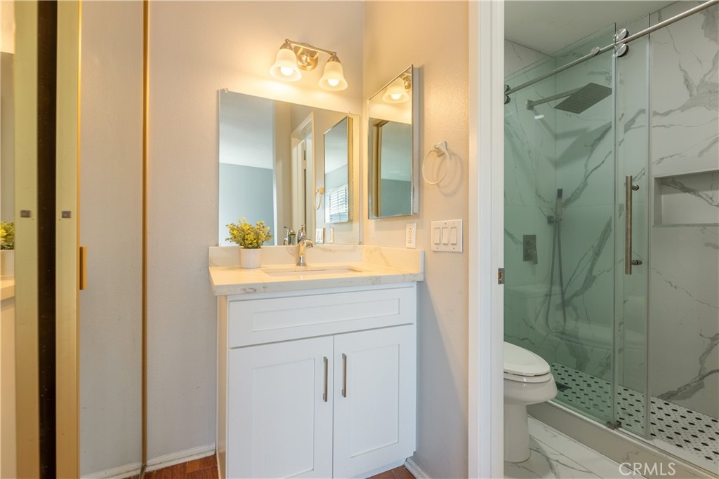 12635 Briarglen Loop, Unit H Stanton, CA 90680 - Photo 26 of 43 a bathroom with a shower sink and mirror
