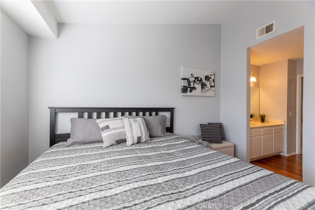 12635 Briarglen Loop, Unit H Stanton, CA 90680 - Photo 30 of 43 a bedroom with a bed and wooden floor