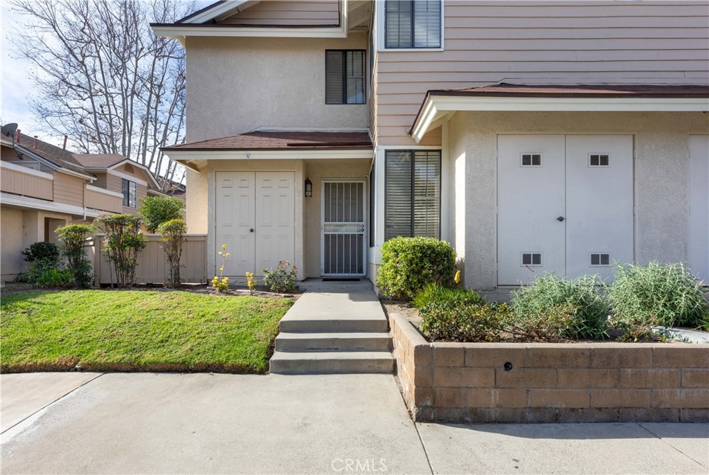 12635 Briarglen Loop, Unit H Stanton, CA 90680 - Photo 3 of 43 a front view of a house with garage and plants