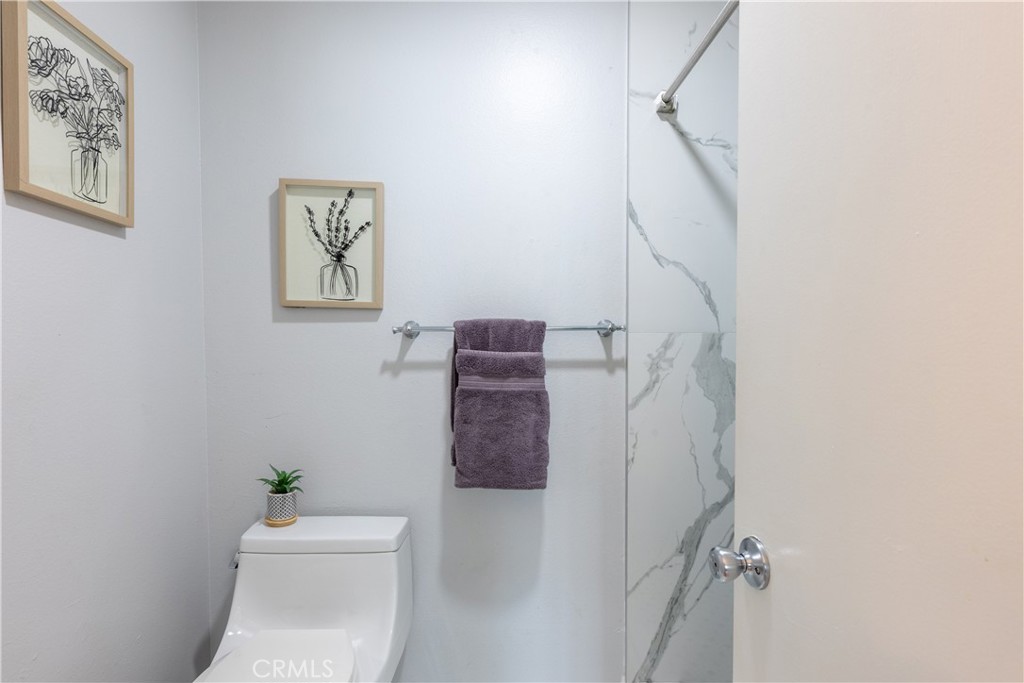 12635 Briarglen Loop, Unit H Stanton, CA 90680 - Photo 34 of 43 a bathroom with a toilet and a shower curtain