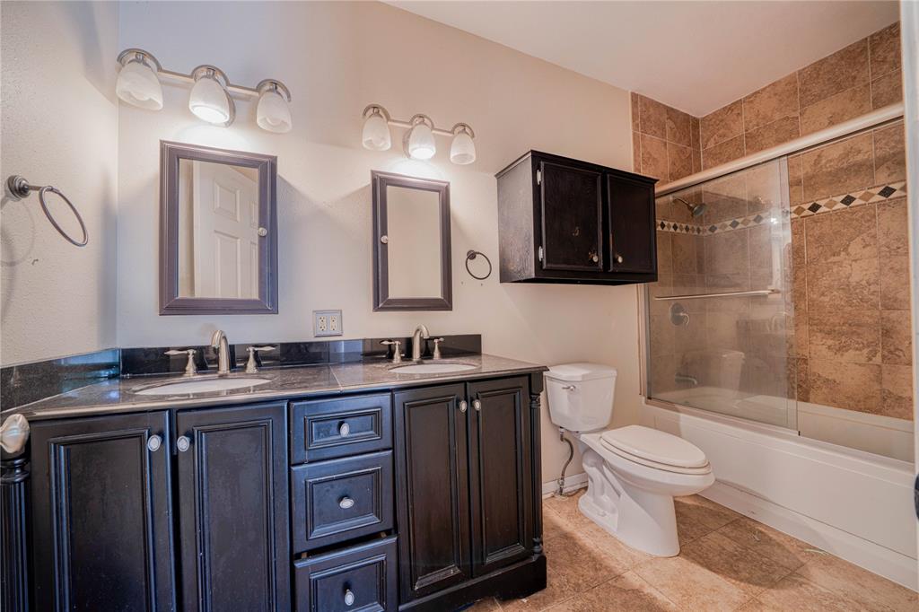 1006 Rikkity Lane Mount Pleasant, TX 75455 - Photo 19 of 39 a bathroom with a granite countertop toilet sink and mirror