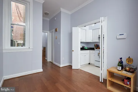 a view of a kitchen with wooden floor and a window