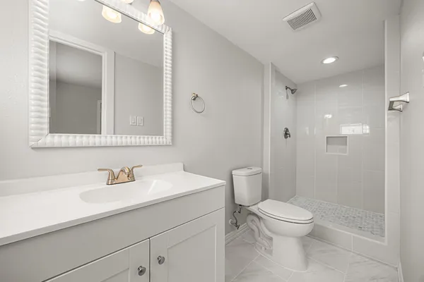 a bathroom with a sink a toilet and shower