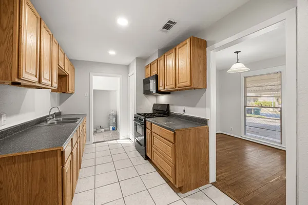 a kitchen with stainless steel appliances granite countertop a stove a sink and a refrigerator