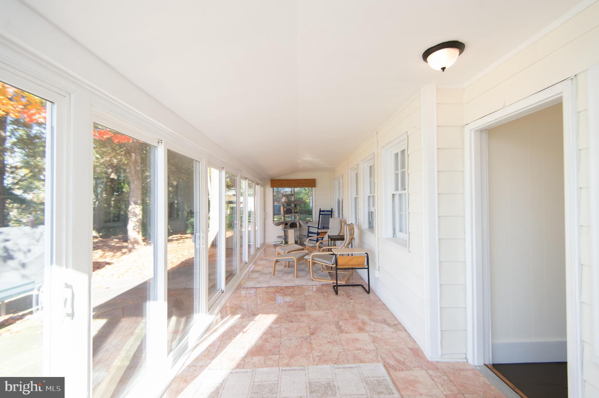 25211 Adams Landing Road Denton, MD 21629 - Photo 34 of 58 a living room with furniture floor to ceiling windows and floor to ceiling window