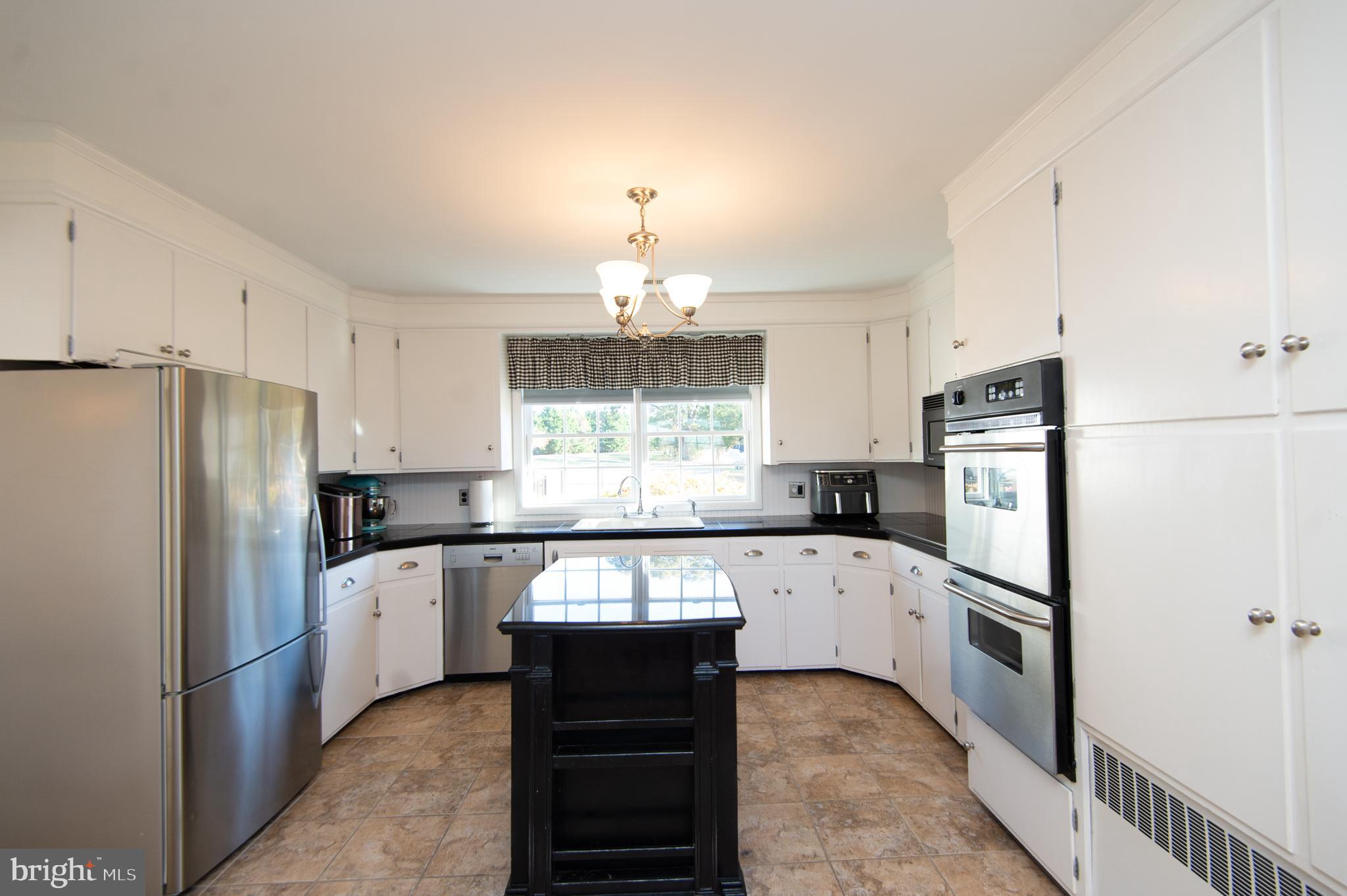 25211 Adams Landing Road Denton, MD 21629 - Photo 40 of 58 a modern kitchen with stainless steel appliances granite countertop a refrigerator and a stove top oven