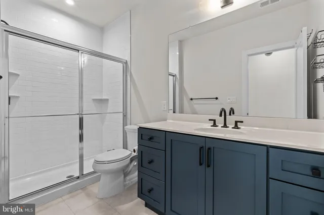 a bathroom with a double vanity sink toilet and shower
