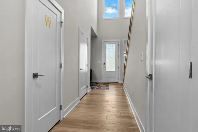 a view of a hallway with wooden floor and a bathroom