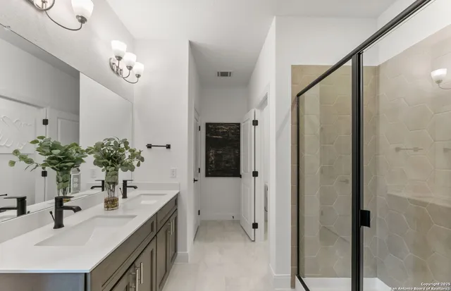 a bathroom with a granite countertop sink a large mirror and a shower