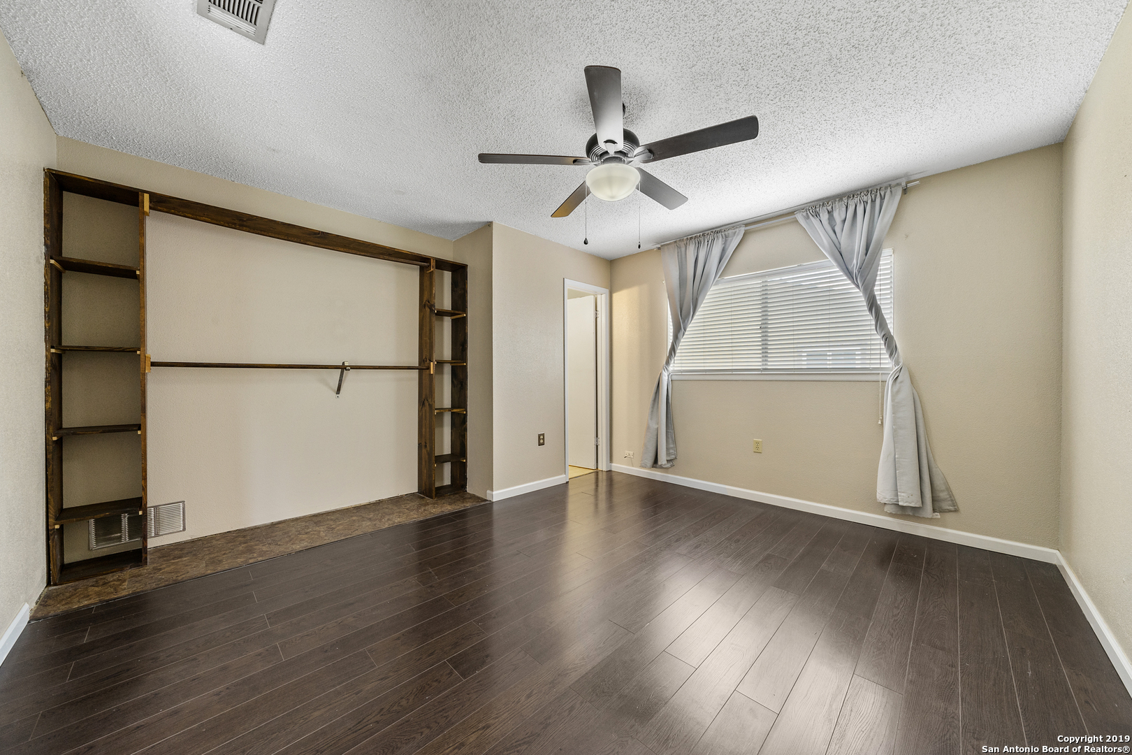 109 Meadow Way Converse, TX 78109 - Photo 12 of 25 an empty room with wooden floor fan and windows