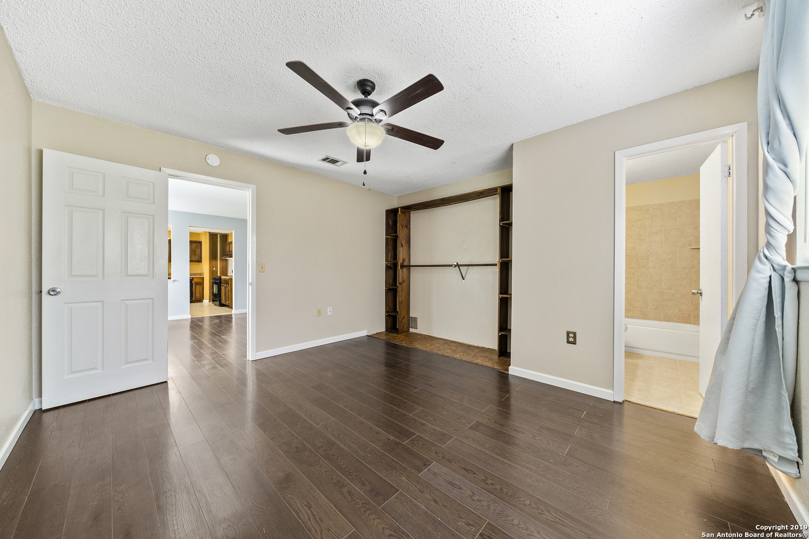 109 Meadow Way Converse, TX 78109 - Photo 13 of 25 a view of an empty room with wooden floor and a window