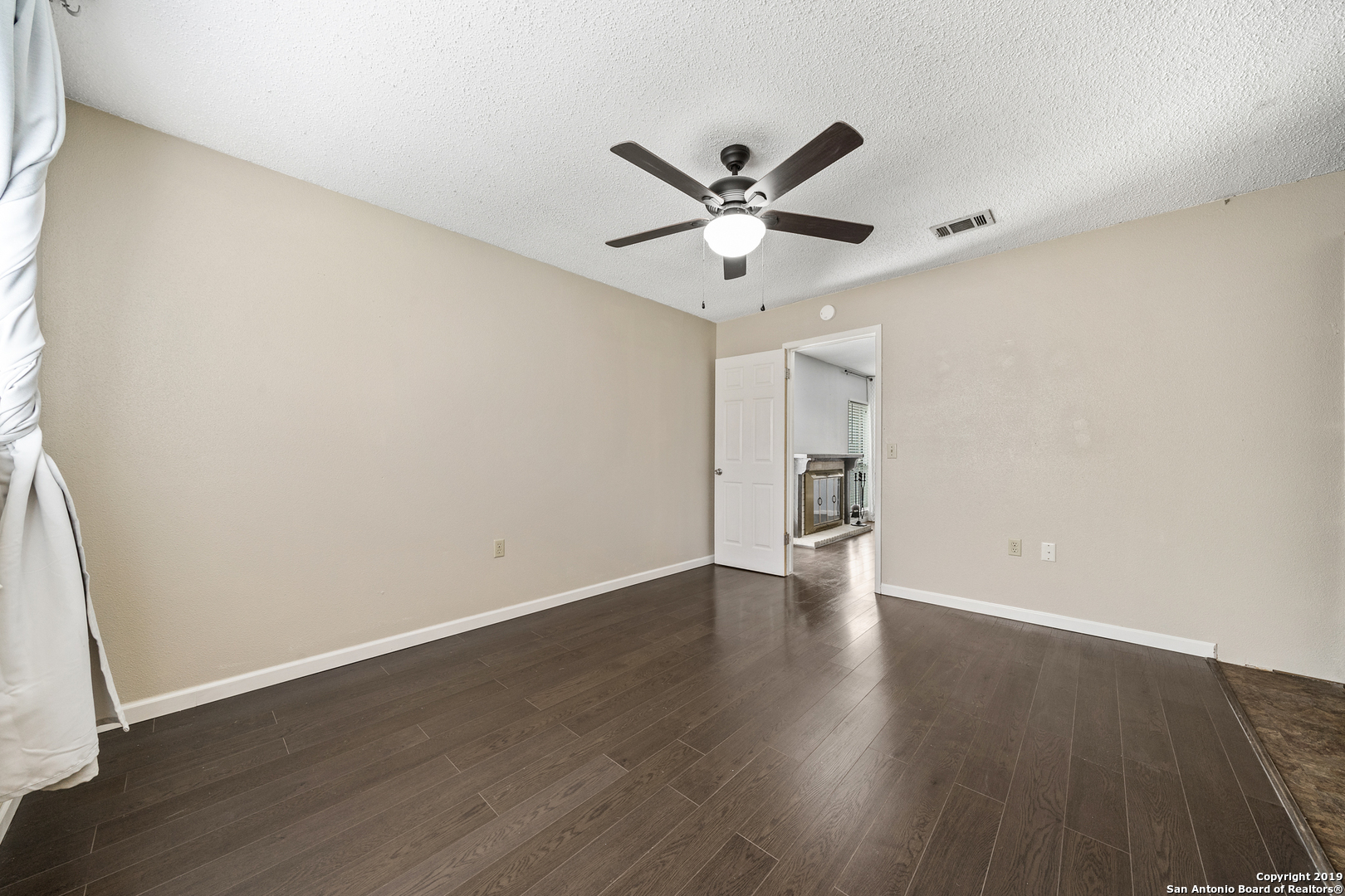 109 Meadow Way Converse, TX 78109 - Photo 14 of 25 a view of an empty room with wooden floor and a window