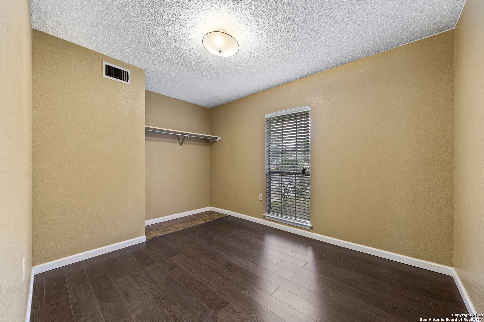 109 Meadow Way Converse, TX 78109 - Photo 16 of 25 an empty room with wooden floor and a window
