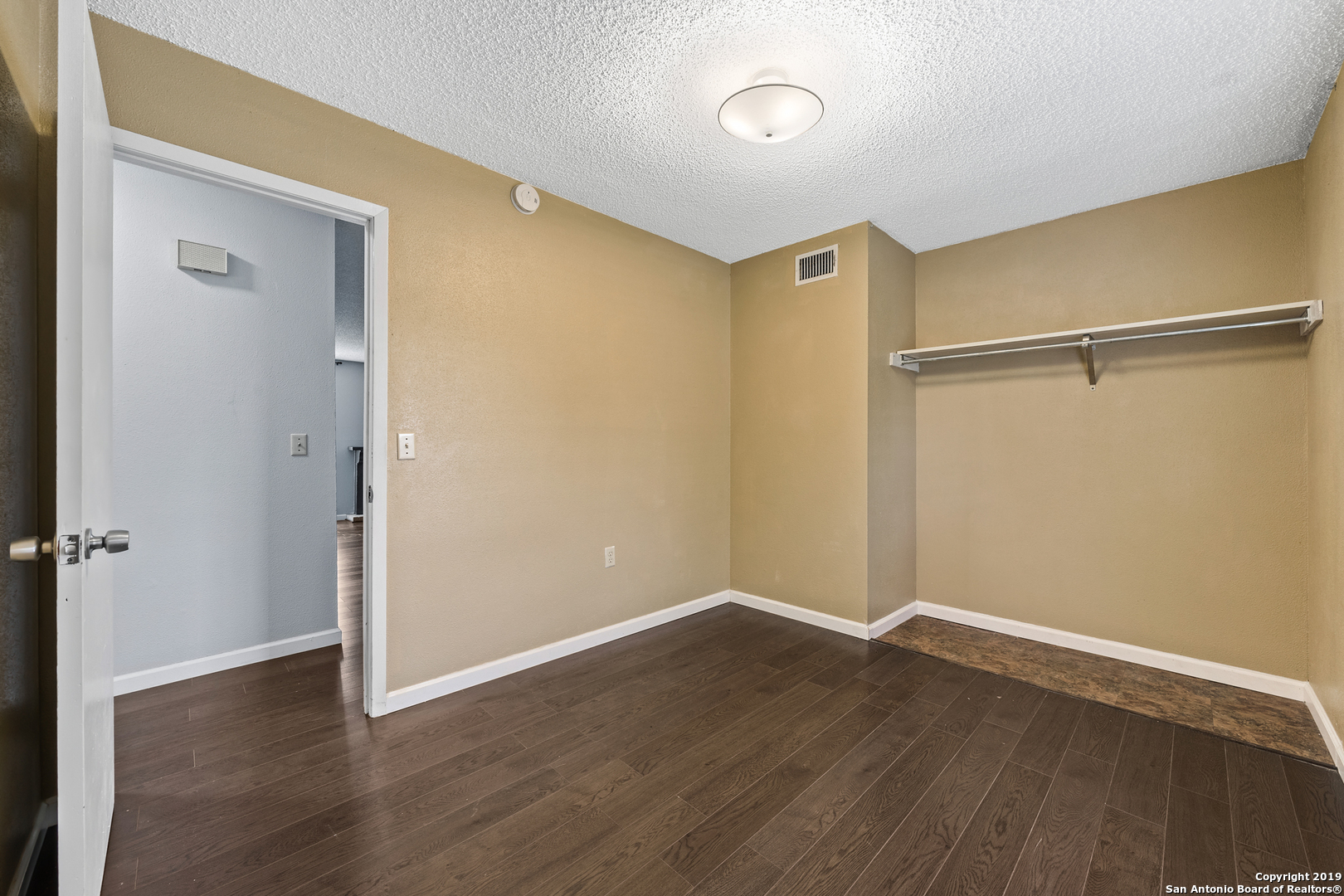 109 Meadow Way Converse, TX 78109 - Photo 17 of 25 a view of an empty room with wooden floor and a window