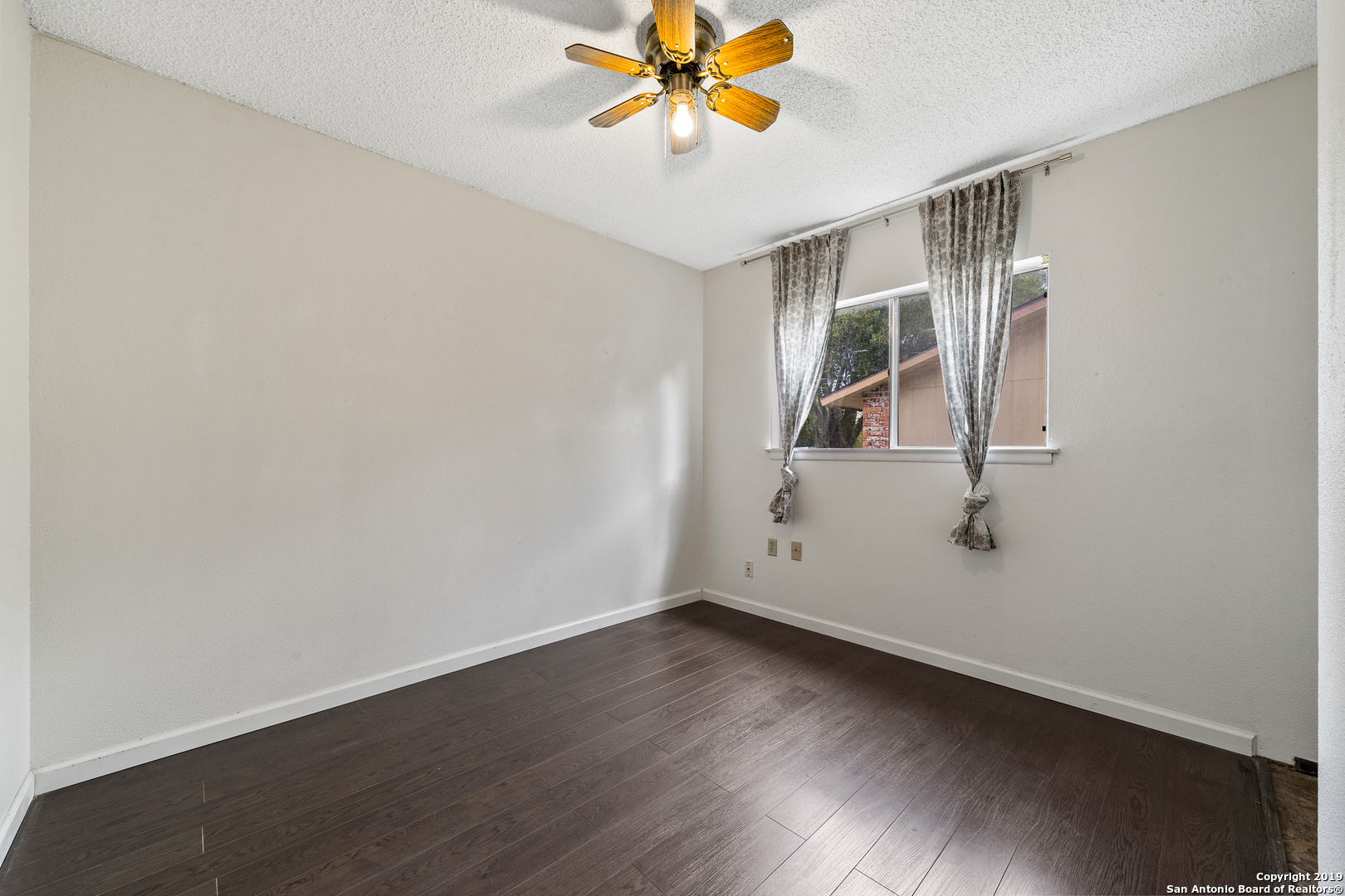 109 Meadow Way Converse, TX 78109 - Photo 19 of 25 an empty room with wooden floor and windows