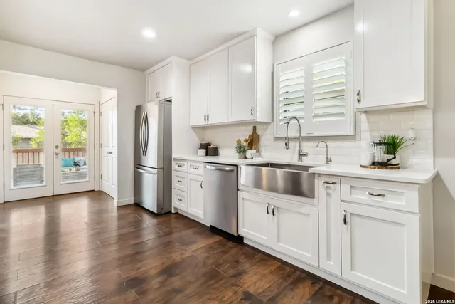 a kitchen with white cabinets and white appliances
