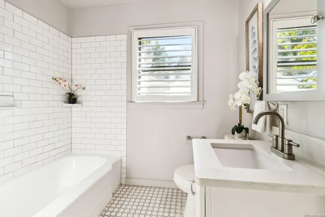 a bathroom with a sink a bathtub and a window