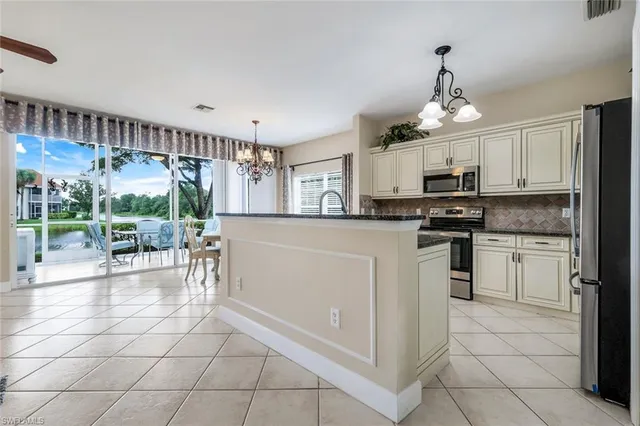 a kitchen with white cabinets and appliances