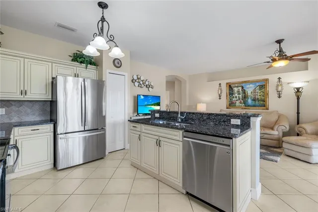 a kitchen with stainless steel appliances granite countertop a refrigerator a stove and a sink