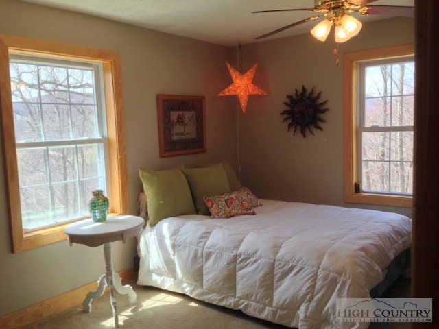620 Green Knob Mountain Road Boone, NC 28607 - Photo 15 of 43 a bedroom with a bed and a chandelier