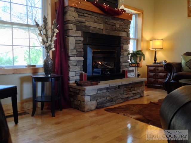 620 Green Knob Mountain Road Boone, NC 28607 - Photo 40 of 43 a living room with furniture a fireplace a flat screen tv and a large window