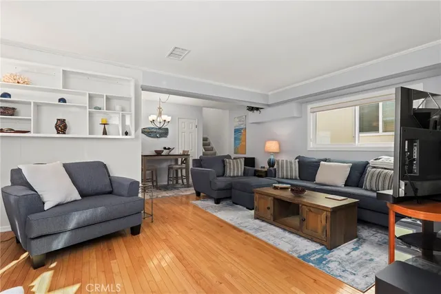 a living room with furniture wooden floor and a flat screen tv