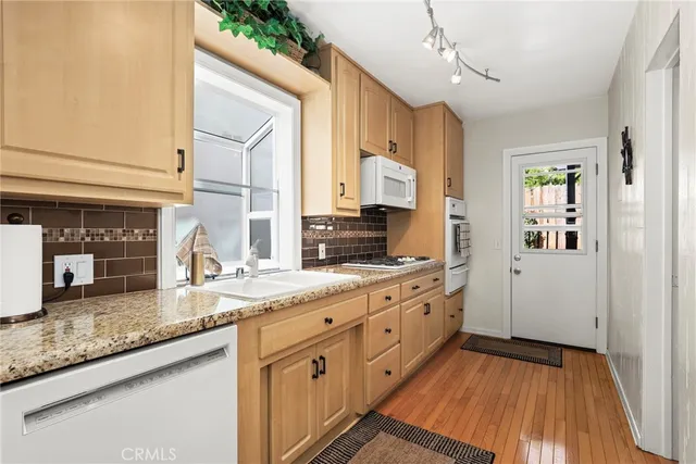 a kitchen with granite countertop a sink stainless steel appliances and cabinets