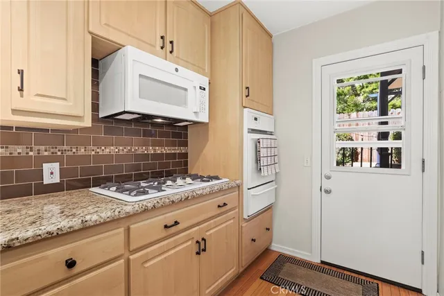 a kitchen with granite countertop white cabinets and white appliances