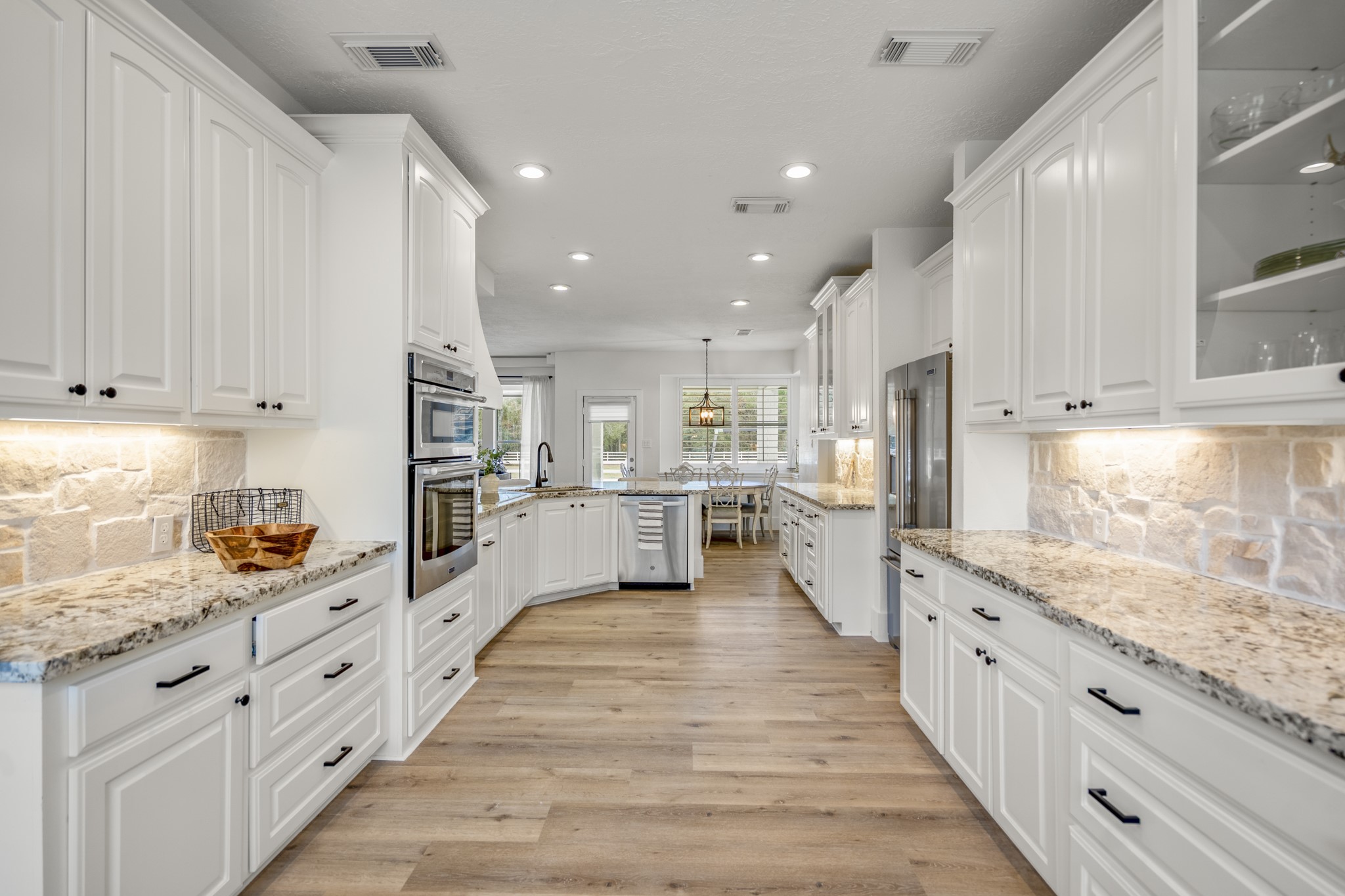 31219 Edgewater Drive Magnolia, TX 77354 - Photo 13 of 49 a large kitchen with stainless steel appliances granite countertop a lot of counter space and wooden floors
