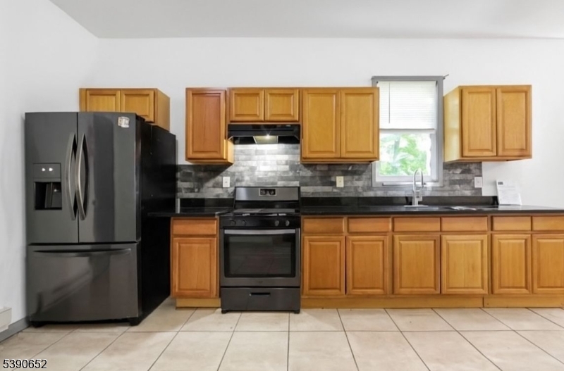 904 South 18th Street Newark, NJ 07108 - Photo 11 of 16 a kitchen with stainless steel appliances granite countertop a refrigerator and a sink
