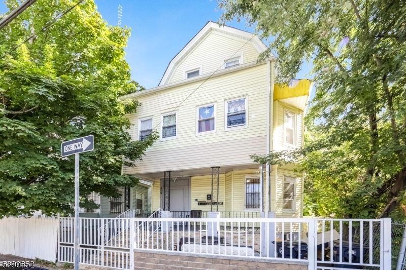 904 South 18th Street Newark, NJ 07108 - Photo 16 of 16 a view of a white house with wooden fence and floor