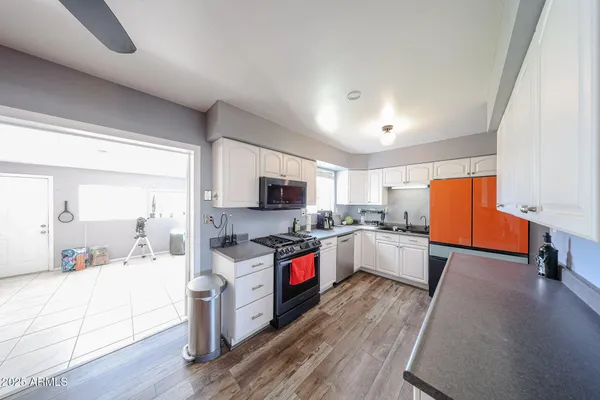 a large kitchen with cabinets wooden floor and stainless steel appliances