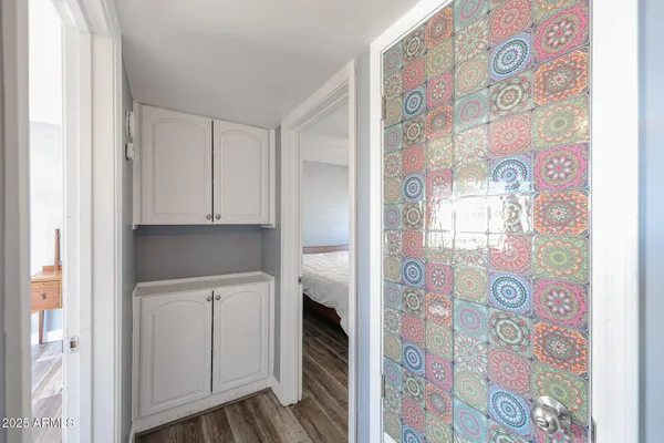 a hallway with cabinets and wooden floor
