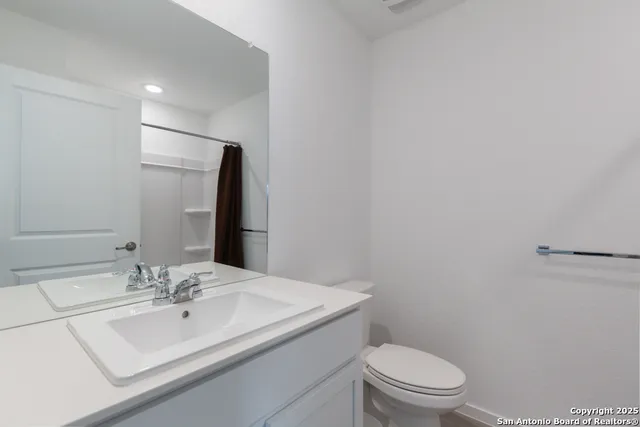 a bathroom with a sink a toilet and mirror