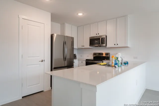 a kitchen with stainless steel appliances granite countertop a refrigerator and a stove top oven