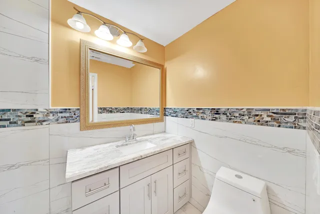 a bathroom with a granite countertop sink and a mirror