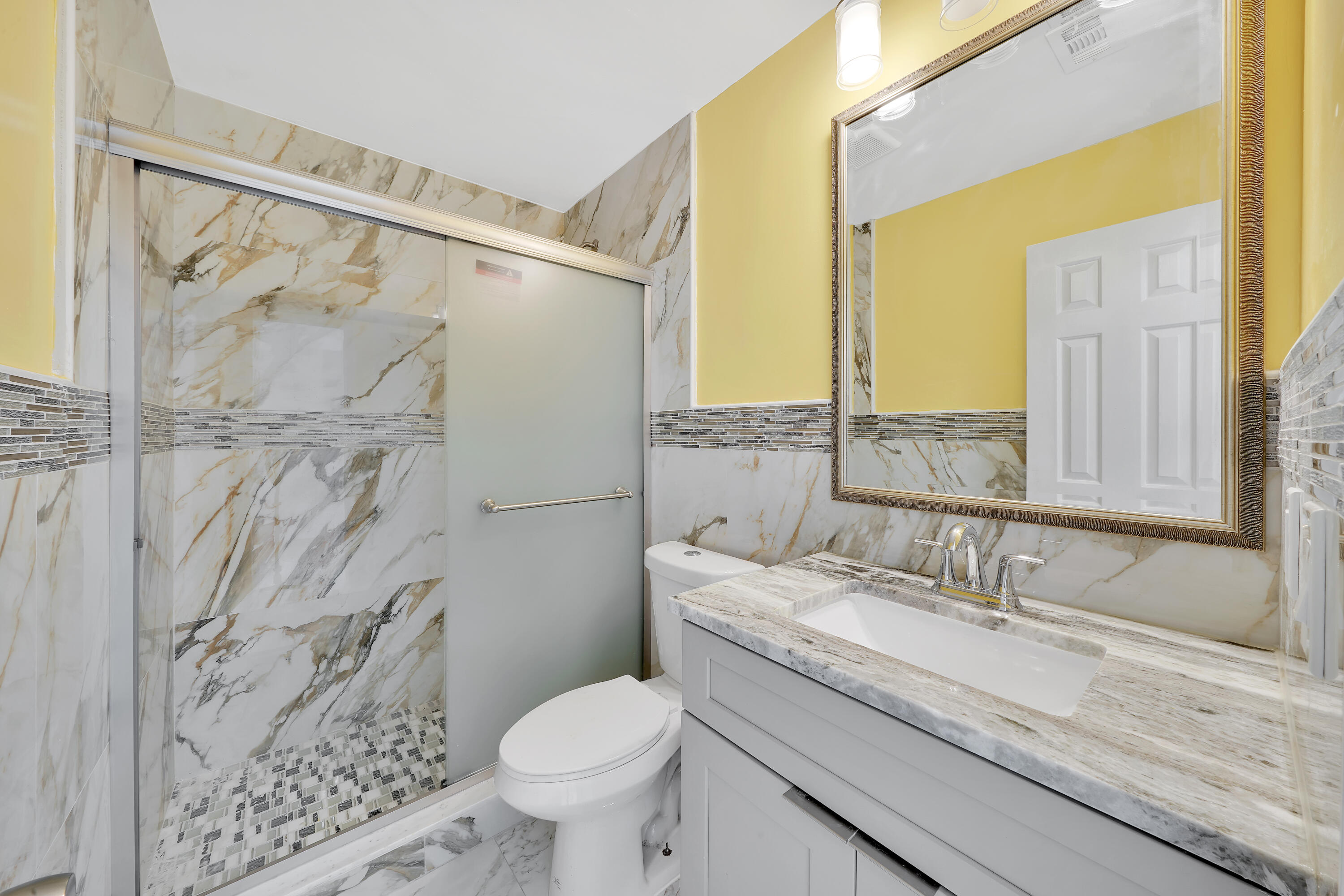724 Ave Chaumont Delray Beach, FL 33445 - Photo 20 of 35 a bathroom with a granite countertop sink a toilet and a shower
