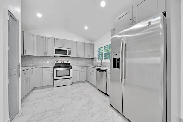 a kitchen with white cabinets and stainless steel appliances