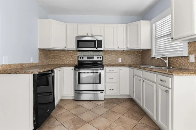 a kitchen with white cabinets and white appliances