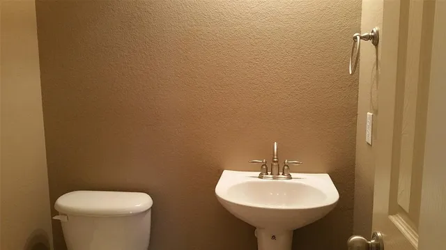 a bathroom with a sink a toilet and mirror