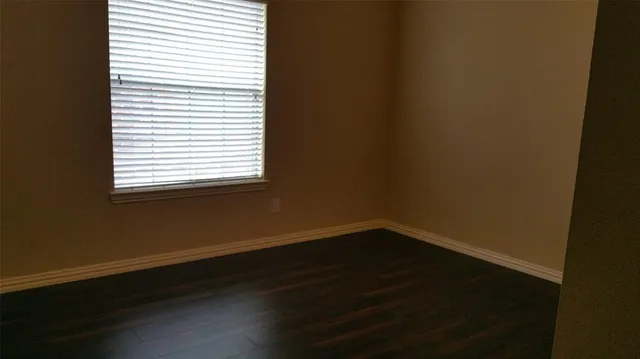 a view of a small space with wooden floor and a window