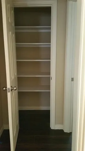 a view of walk in closet with empty racks