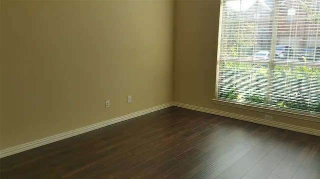 a view of a room with wooden floor and a window
