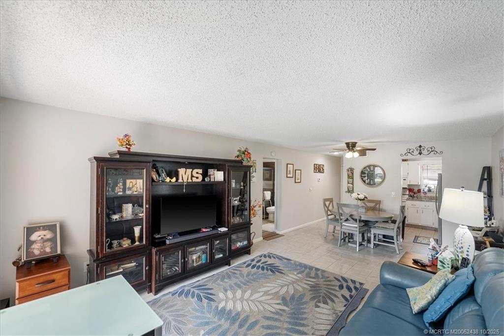 1969 Southwest Palm City Road, Unit C Stuart, FL 34994 - Photo 2 of 23 a living room with furniture and a flat screen tv