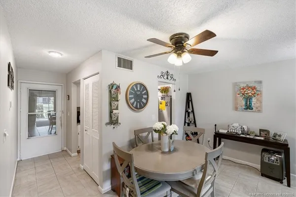 a view of a dining room with furniture and a chandelier fan