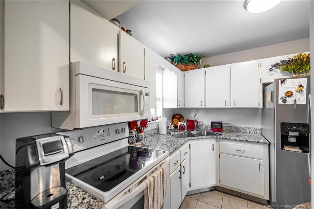 1969 Southwest Palm City Road, Unit C Stuart, FL 34994 - Photo 6 of 23 a kitchen with cabinets a washer and dryer